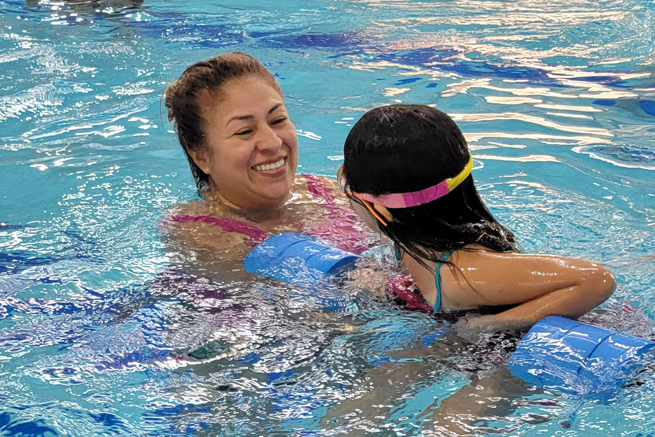 Child and her guardian smiling during swim lessons.