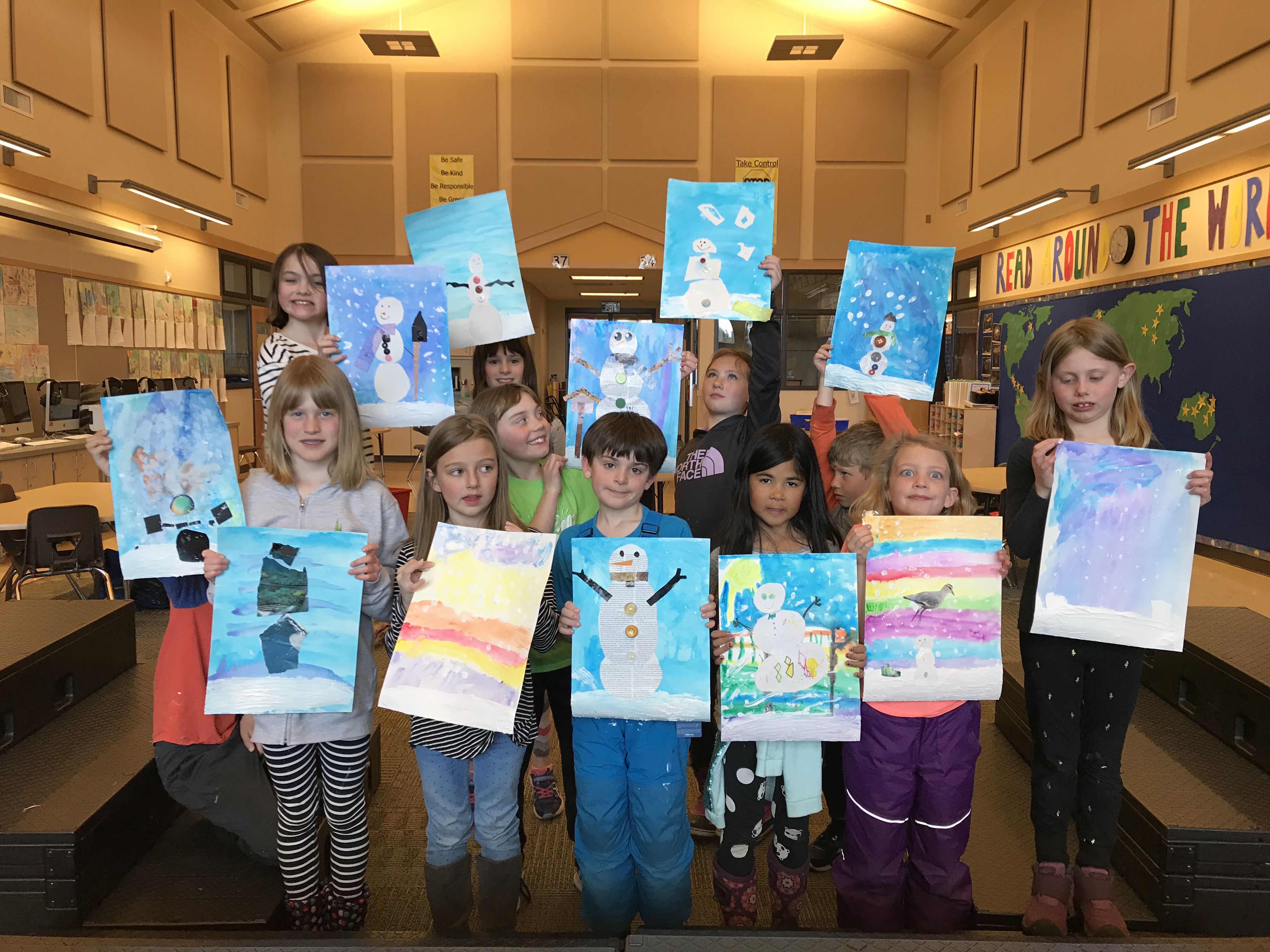 elementary school children showing art projects featuring snowmen