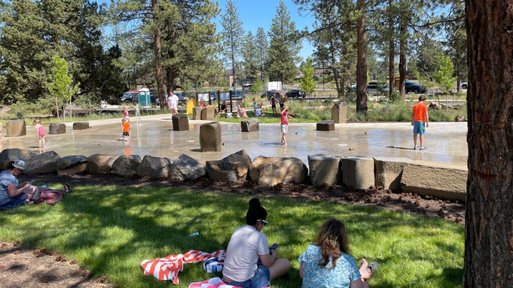 parents watching their kids play on the alpenglow sprayground