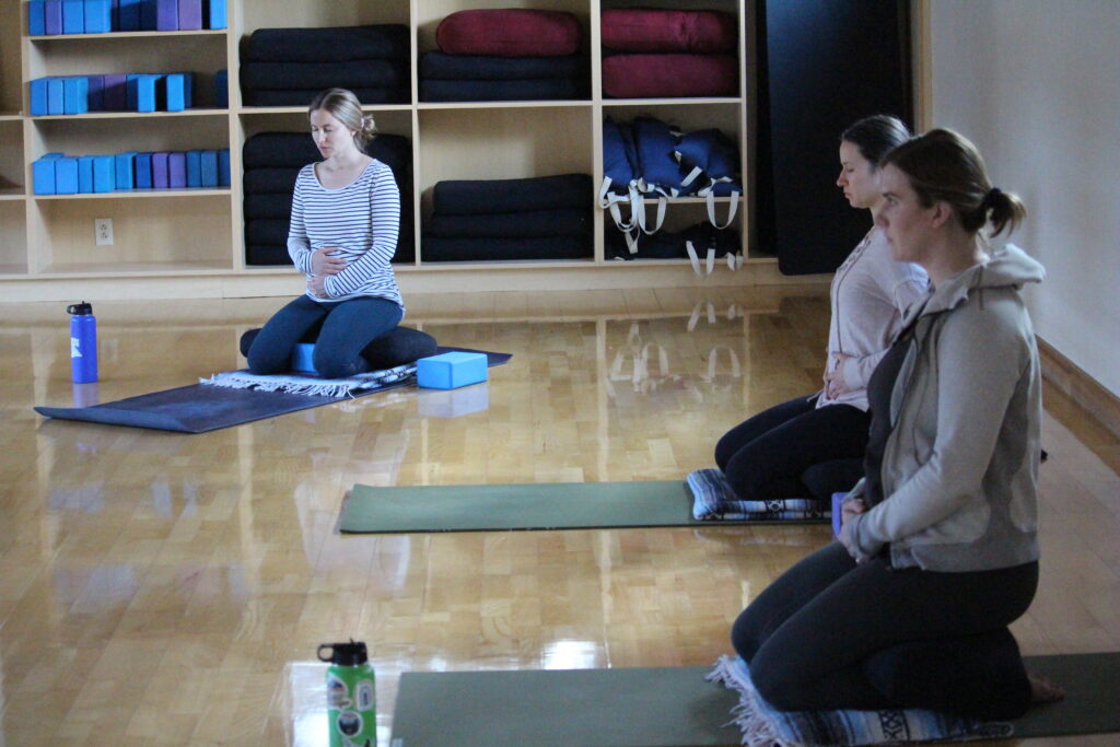 three women participating in a prenatal yoga class