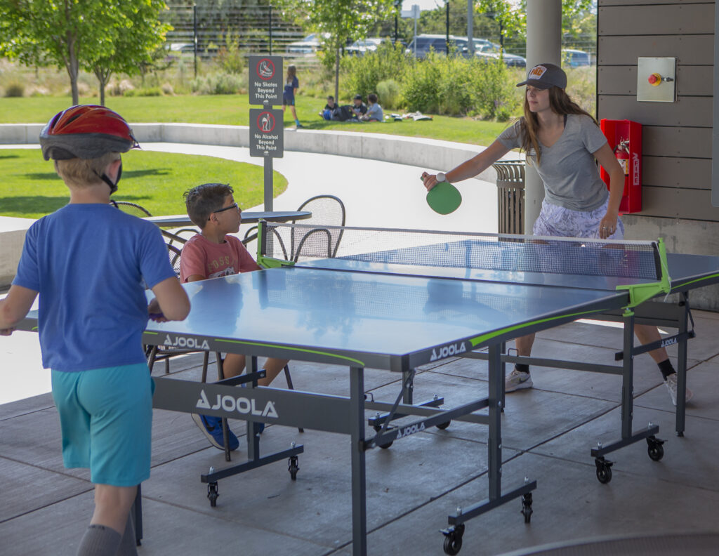 a youth rec leader plays ping pong with a boy