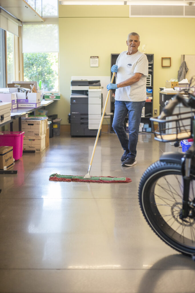 a custodian pushes a broom