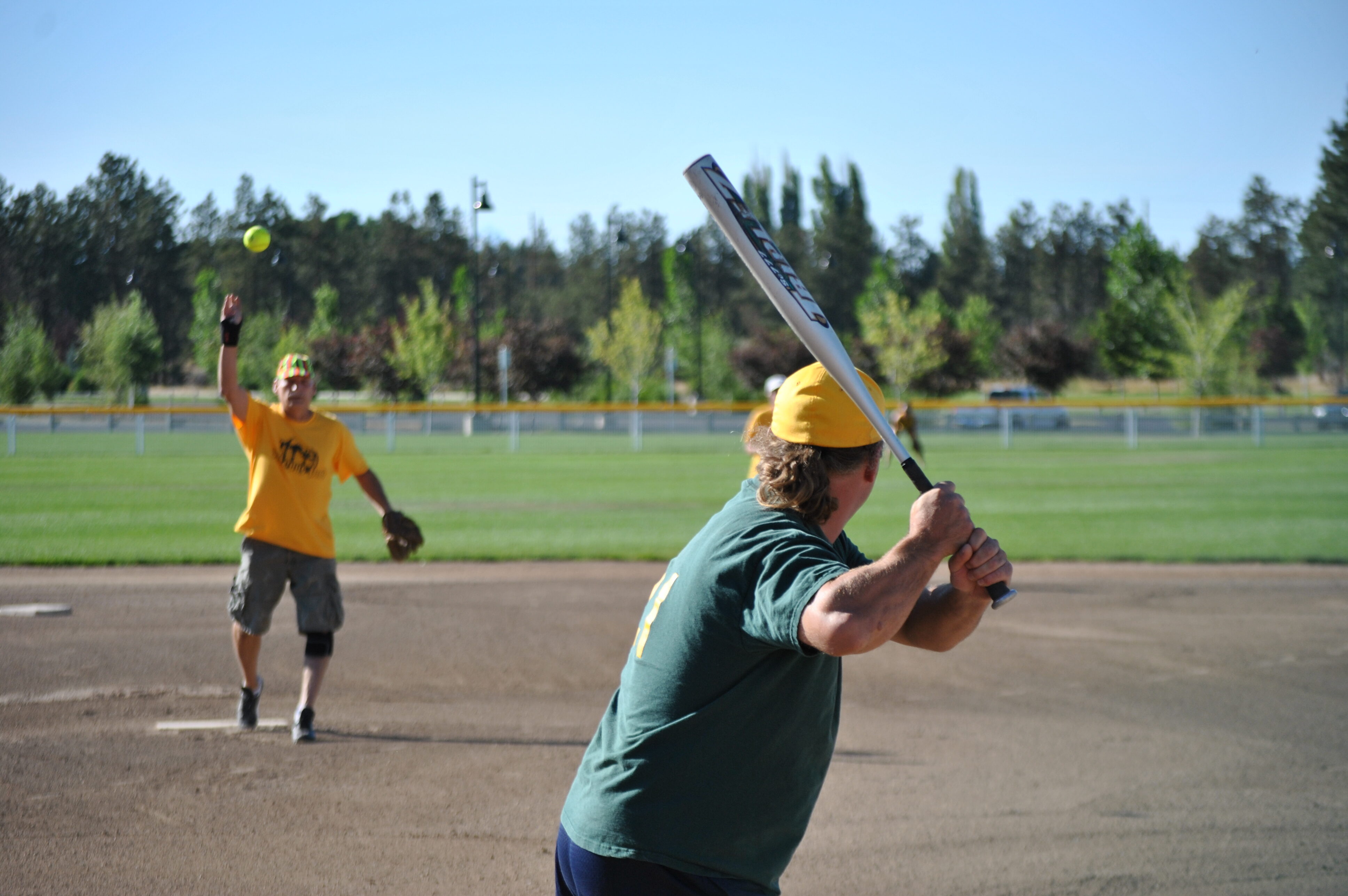 a slow pitch softball pitcher pitches a ball at pine nursery park