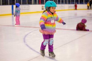 young ice skater in lesson