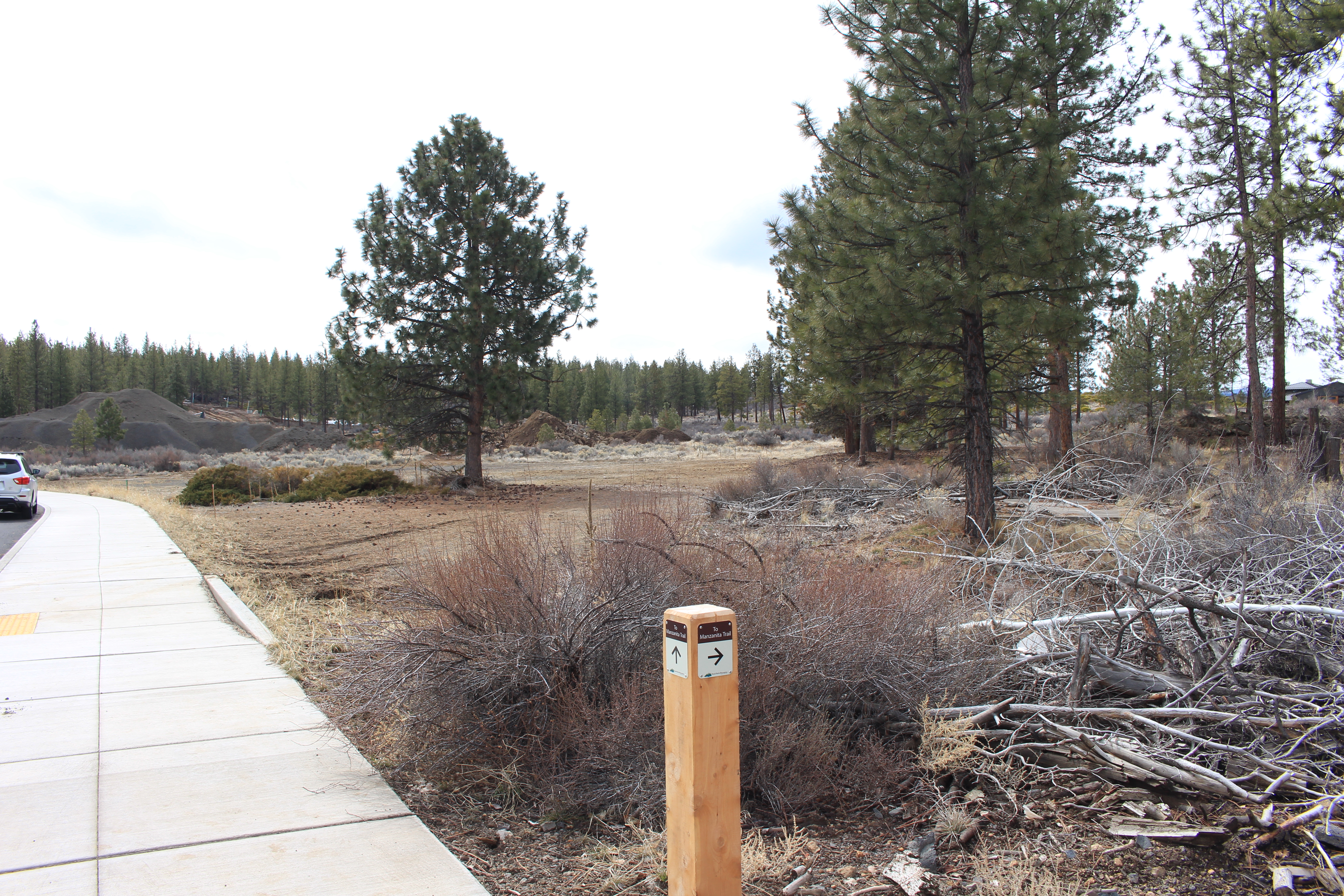 Sidewalk view of the new Shevlin West park site with trail marker