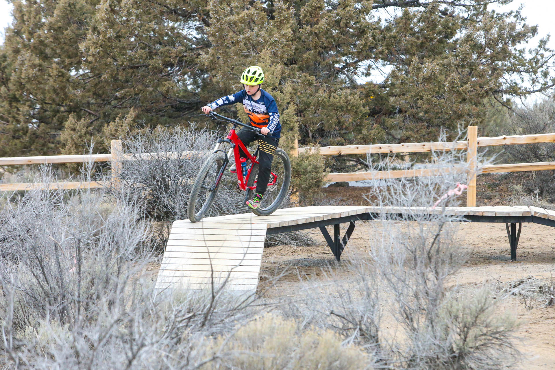 a cyclists on a mountain bike rides on an elevated wood ramp