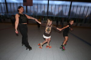Photo of a mother and two young daughters roller skating at a Pavilion roller party.
