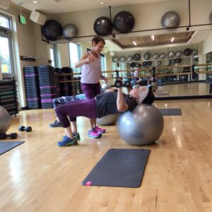 Personal trainer works with patrons in the fitness room at Larkspur.