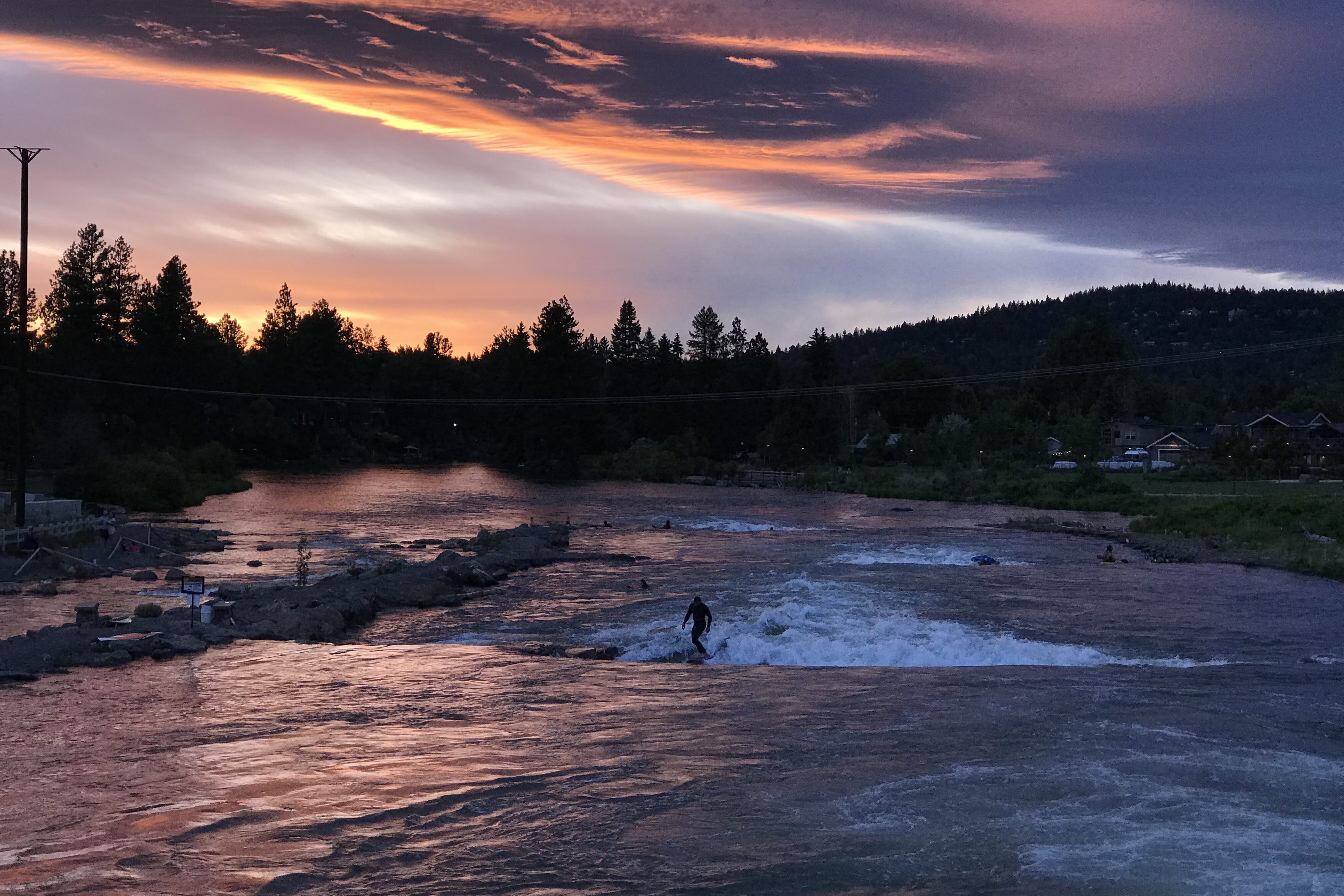 A lone surfer uses the wave at sunset