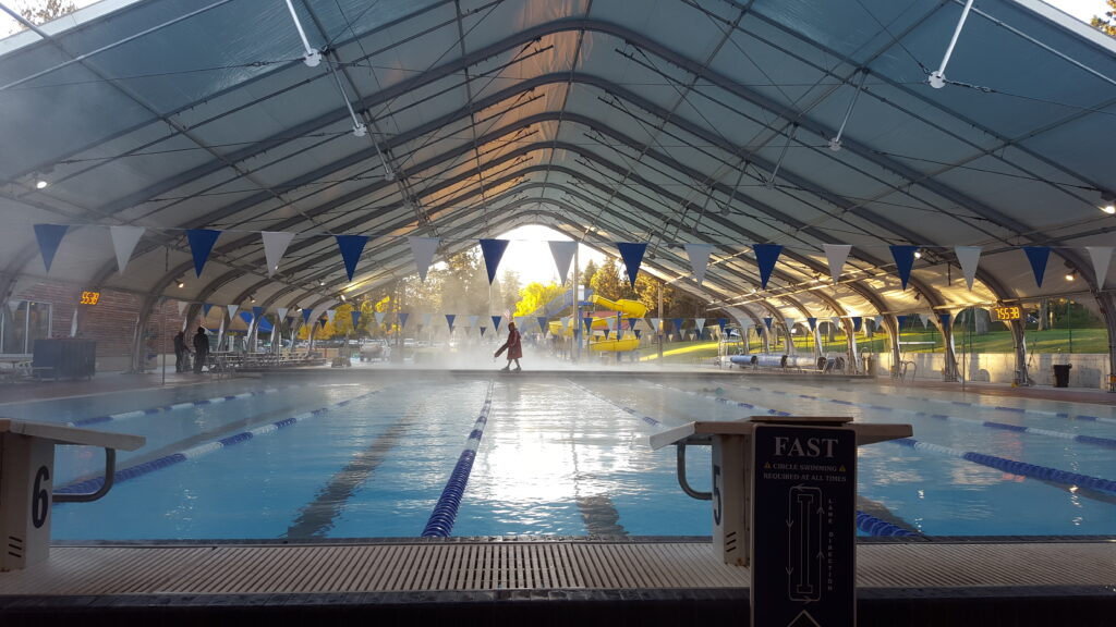 Open air covered pool photo with lifeguard on bulkhead