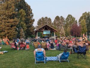 Patrons in chairs watching outdoor movie
