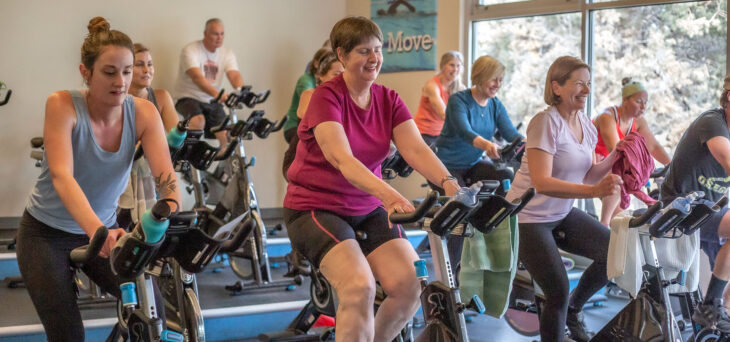 Wide shot of a full indoor cycling class.