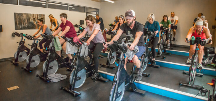 Large group at an indoor cycling class.