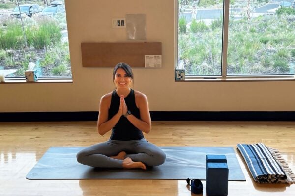 yoga instructor poses on the floor in a classroom