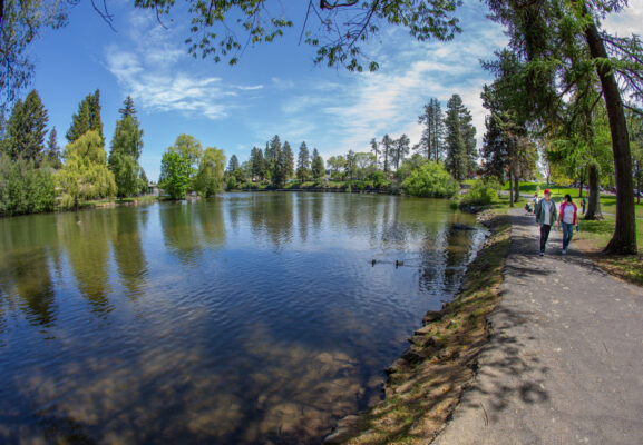 Photo of the Deschuttes river trail between Drake and Pioneer Park, with two people walking along the river.