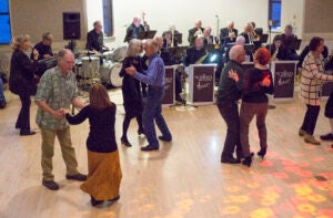 Adults dancing on dance floor with live band in background