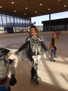 woman dressed in skeleton costume while ice skating