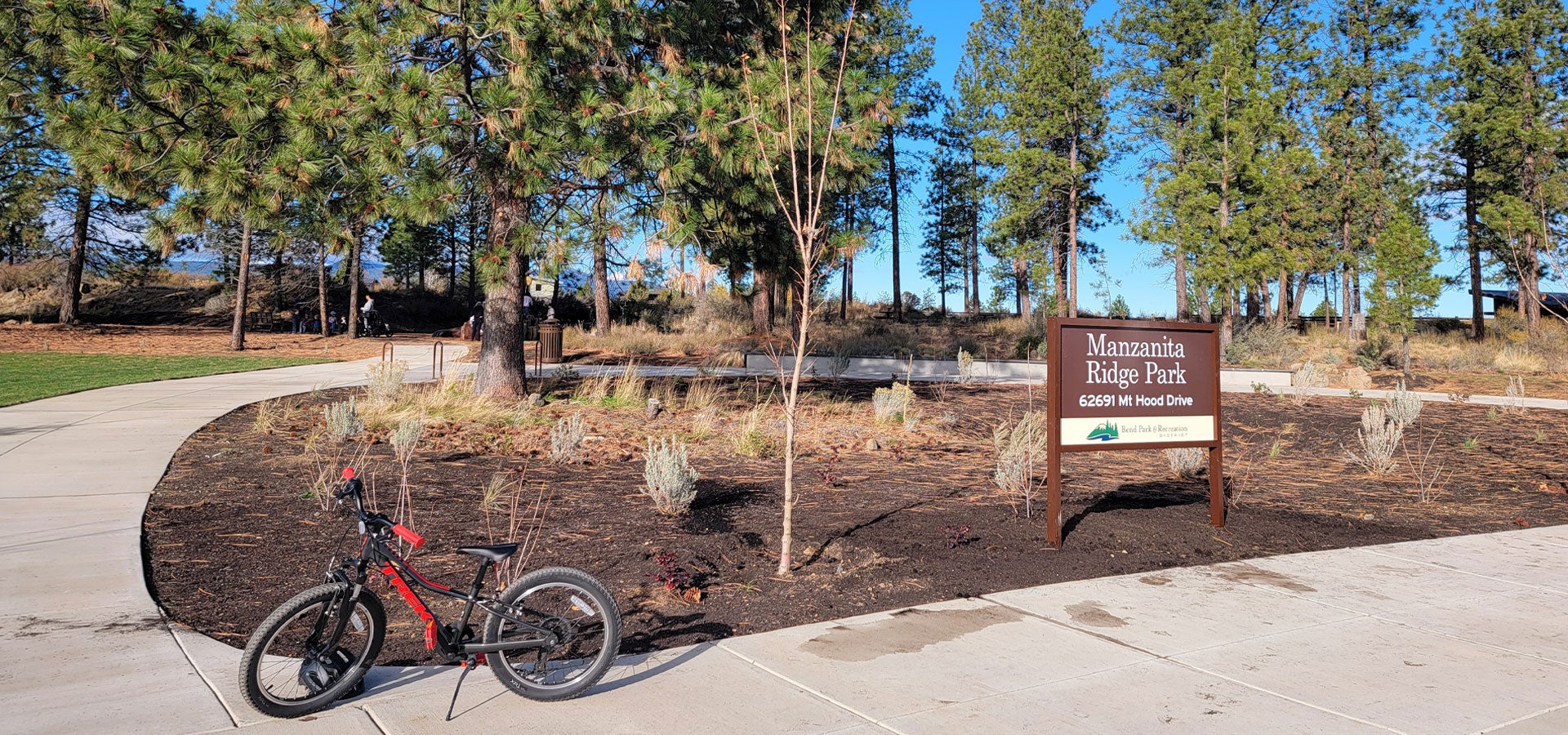 Photo of the park entrance with sign and bike at Manzanita Rdige Park