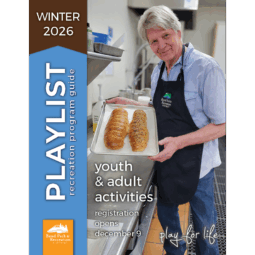 Older adult patron in a bread baking class shows off his two bread loaves with a proud smile.