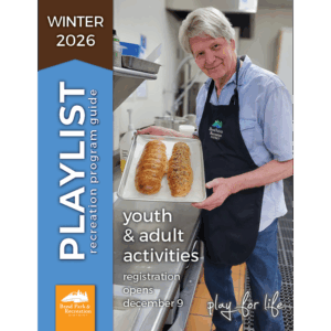 Older adult patron in a bread baking class shows off his two bread loaves with a proud smile.