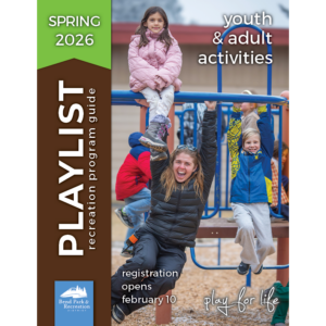 Youth recreation staff member laughs at hte camera while playing on the playground equipment with kiddos at a Kids Inc. activity.