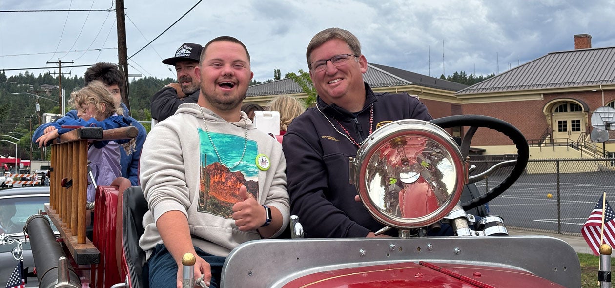 Photo of patrons driving an old time fire truck in the parade.