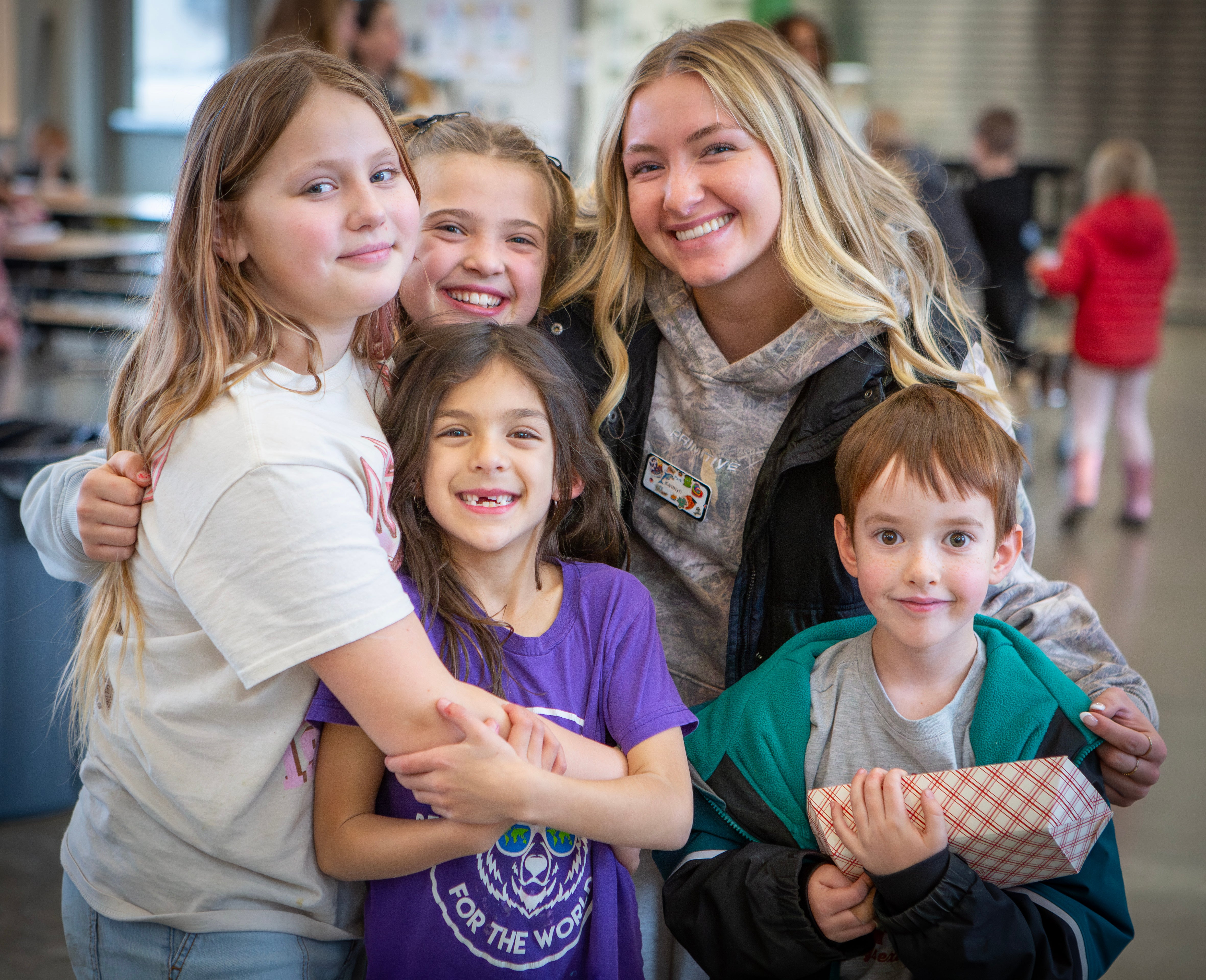 Adult youth recreation leader smiling with children in Kids Inc.